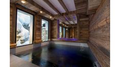 an indoor hot tub in the middle of a room with wooden walls and windows on both sides