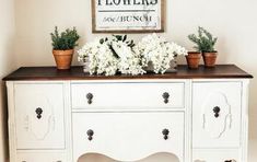 a white dresser with flowers on top