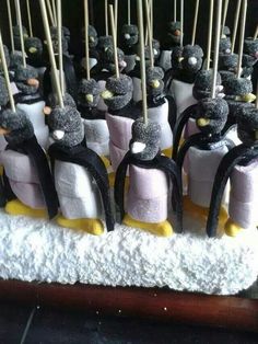 there are many small penguins on top of marshmallows with sticks sticking out of them