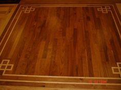 a wooden floor with an intricate design on the top and bottom edge, in a room with hardwood floors