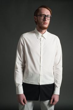 An elongated tunic shirt with black and white color block design by ARIEL BASSAN.ARIEL BASSAN is a sophisticated and contemporary menswear brand, that offers a unique and fresh high quality garments with a distinct signature of modern minimalism.This shirt is made out of a 100% Cotton, Crisp Woven Fabric. It has a contrasted hem panel with a ribbed tape detail.The extremely modern longline silhouette, with a longer back hem, will give you a slim and elongated sophisticated look.Model's height is Modern White Long Sleeve Dress Shirt, Modern Semi-formal Spring Dress Shirt, Modern Button-up Dress Shirt, Modern Office Shirt, Modern White Dress Shirt For Spring, Modern White Dress Shirt For Work, Modern Semi-formal Shirt With Relaxed Fit, Modern Relaxed Fit Shirt For Semi-formal Occasions, Modern Semi-formal Cotton Tops