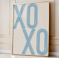 an xoxo sign is displayed in front of a white wall with gold trim