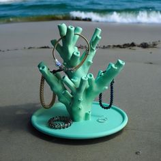 a ring holder made to look like a tree on the beach