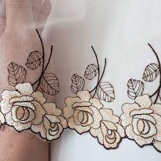 a close up of a person's arm with lace on it and flowers in the middle