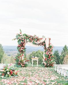 an outdoor ceremony setup with flowers and greenery