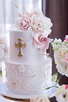 a wedding cake with flowers and a cross on top