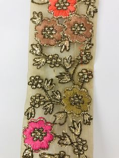 an old piece of cloth with flowers on it and sequins in the middle