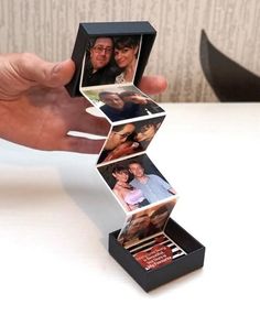 a person is holding an open box with photos in it