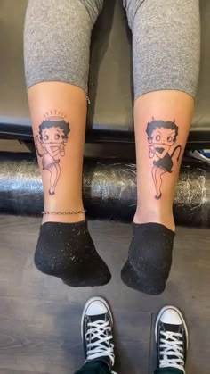 two people with tattoos on their legs