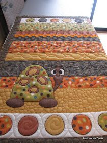 an appliqued quilt with a turtle on it's side and circles in the middle