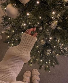 someone's feet in front of a christmas tree