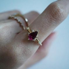 A beautiful garnet set in 14K solid gold. The gorgeous ring for an understated classy look. Handcrafted in your choice of 14K Yellow gold, Rose gold and white gold. A classy piece to treasure for time to come. Materials: - 14K solid gold - 7x5mm natural pear-shaped garnet stone - Round CZs (what's this?) ** This item is specially made for you. Please allow 1-2 week lead time. Shipping: Domestic: Free standard shipping within the U.S. International: Free standard shipping for orders over $150 Cus Elegant Teardrop Ruby Rings, Fine Jewelry 14k Gold Pear-shaped Ruby Ring, 14k Gold Pear-shaped Ruby Ring, 14k Gold Pear-shaped Ruby Ring For Wedding, 14k Gold Pear-shaped Birthstone Ring, Elegant Pear-shaped Red Rings, Elegant Red Pear-shaped Rings, Sky Blue Topaz Ring, Heart Shoes