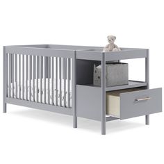 a baby crib with drawers and a teddy bear