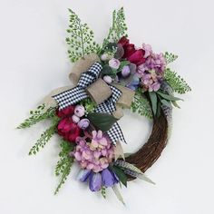 the wreath is decorated with flowers and greenery