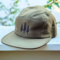 🌲🌲 5% of profits donated to preservation 🌲🌲  Gear up for your next adventure with our olive green tree 5 panel hat, the ultimate camp hat! Crafted from 100% cotton, this hat's flat bill keeps you cool and shaded as you conquer trails, lounge by the campfire, or explore the great outdoors. Your new adventure-ready essential! This hat is olive green with black embroidered trees on the front. Embroidery is custom designed by the shop owner, Alyssa, stitched on front. - 100% cotton - 5 Panel, Camp Hat - Head circumference: 19⅝″-22½″ - Flat Bill - Nylon adjustable strap - Custom embroidery, on the front center - Hand wash, dry flat - Olive green hat - The perfect hiking gift, camping gift and nature gift! Green Short Brim Baseball Cap For Outdoor Activities, Green Short Brim Hat For Camping, Khaki Outdoor Hat With Short Brim, Green Flat Bill Baseball Cap For Outdoor Activities, Adjustable Khaki Hat For Hiking, Khaki Hat With Short Brim For Outdoor, Green Flat Brim Baseball Cap For Outdoor, Green Snapback Hat With Short Brim For Outdoor, Khaki Curved Brim Bucket Hat For Camping