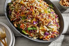 a salad with coleslaw, nuts and carrots in a bowl on a table