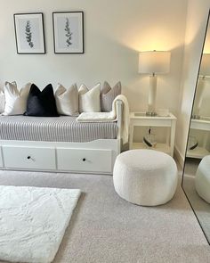 a living room with a couch, ottoman and mirror