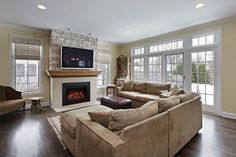 a living room filled with furniture and a flat screen tv mounted on the wall above a fireplace