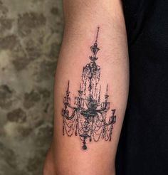 a black and white photo of a chandelier tattoo