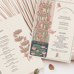 the wedding program is displayed next to an open fan with pink flowers and leaves on it