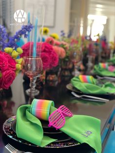 the table is set with colorful napkins and place settings