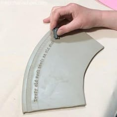 a person cutting out a piece of paper with a sharp knife on top of it