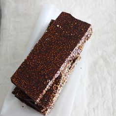 a piece of chocolate cake sitting on top of a white plate with sprinkles