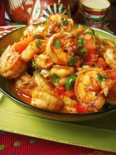 a pan filled with shrimp and vegetables on top of a table