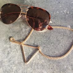 sunglass-strap-sintillia-triangle-croakie Trendy Metal Sunglasses, Trendy Gold Aviator Sunglasses With Glass Lenses, Metal Sunglasses With Uv Protection And Adjustable Fit, Adjustable Metal Sunglasses With Uv Protection, Gold Aviator Sunglasses With Glass For Beach, Gold Aviator Sunglasses With Glass Lenses For Beach, Gold Glass Aviator Sunglasses For Beach, Trendy Metal Glasses Chain, Trendy Metal Glasses Chains For Summer