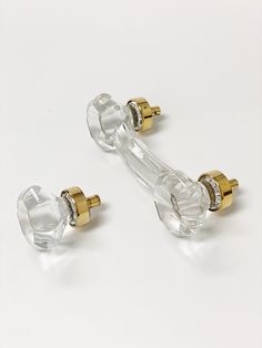 two clear glass door handles with gold accents