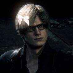 a young man with glasses and a bow in his hair is staring at the camera