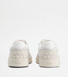 A sporty and sophisticated taste characterizes these sneakers with basketball-inspired upper, and side Tod's logo. Crafted in calfskin suede with smooth leather inserts, they come with a rubber outsole with embossed rubber pebbles. Back To Black, White Sneakers, Smooth Leather, Grey And White, Calf Skin, Basketball, Sneakers, Leather, White