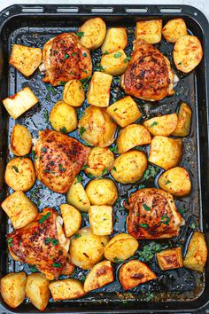 chicken and potatoes on a baking sheet with parsley in the middle, ready to be cooked