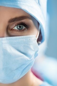 a woman wearing a surgical mask looking at the camera