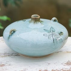 a blue vase sitting on top of a wooden table