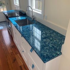 a kitchen with blue counter tops and white cabinets