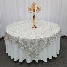 a white table with a gold candelabra sitting on it's top