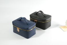 two black and blue suitcases sitting next to each other on a white table top