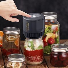 a person touching the top of a jar filled with food