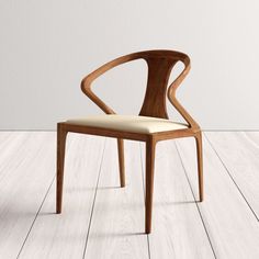 a wooden chair sitting on top of a hard wood floor next to a white wall