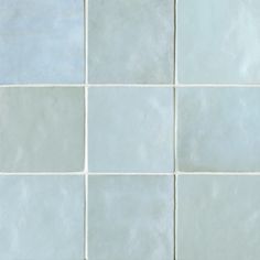 a white tiled wall with blue and gray tiles