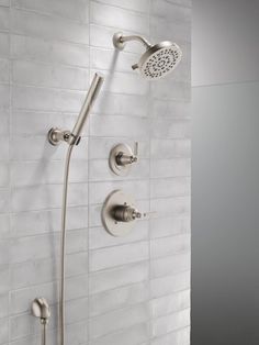 the shower head and hand shower faucet are shown in this bathroom setting with white tile