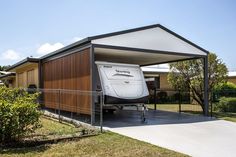 an rv is parked in front of a house with a carport attached to it