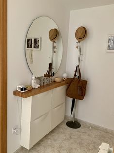 there is a mirror and some hats on top of the counter in this bathroom area