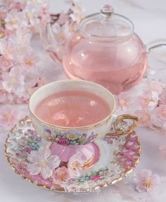 a tea cup and saucer with pink liquid in it