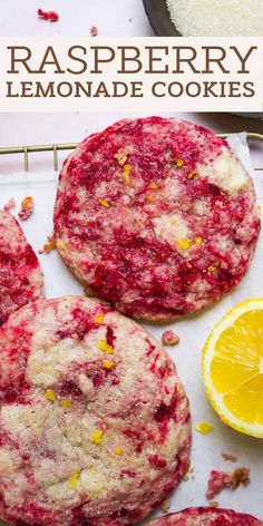 raspberry lemonade cookies on a cooling rack with oranges and powdered sugar