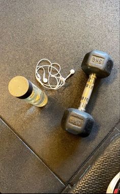 two dumbbells and a bottle of water sitting on the floor next to each other