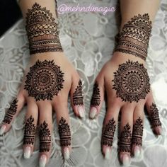 two hands with henna tattoos on them