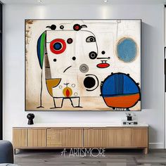 an abstract painting hangs on the wall above a large wooden cabinet in a modern living room