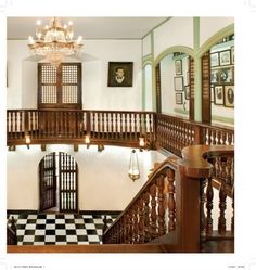 an ornate staircase with chandelier and checkered flooring in a large house